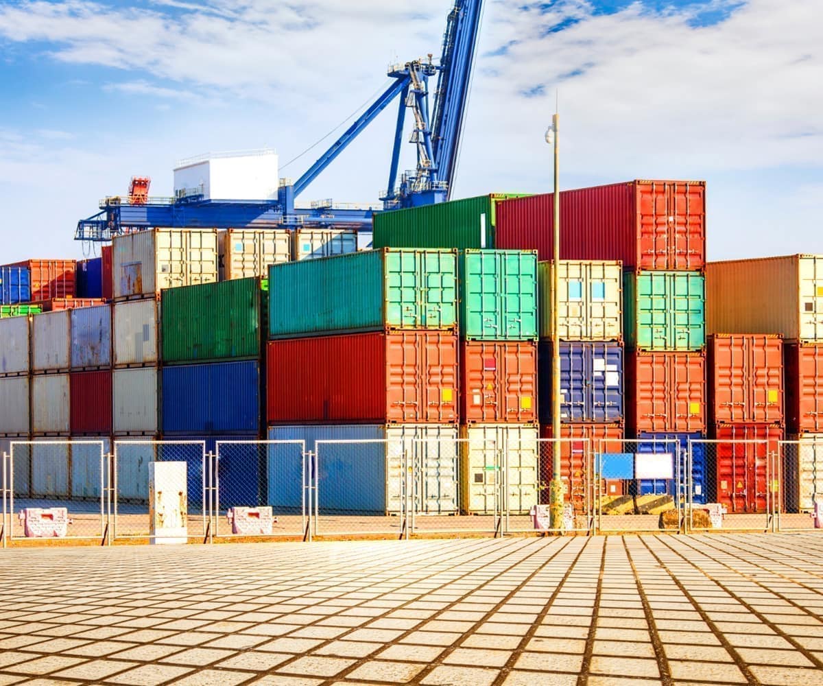 Colorful shipping containers stacked at a freight terminal